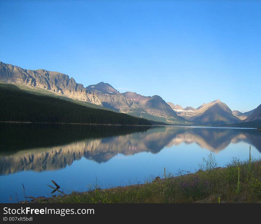 An early morning mountain range perfectly reflected in the water below. An early morning mountain range perfectly reflected in the water below