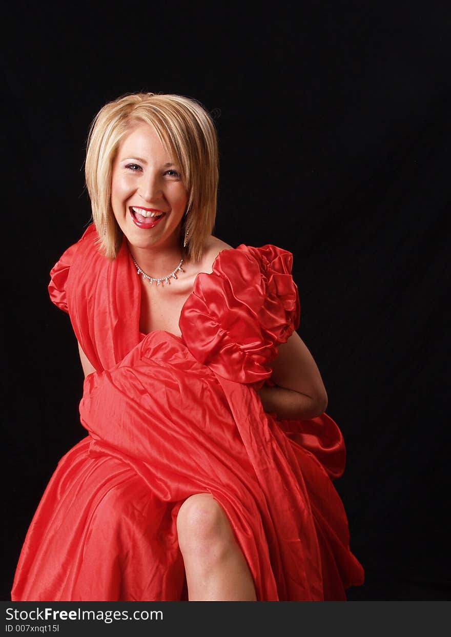 Young model wrapped in red against a black backdrop. Young model wrapped in red against a black backdrop.