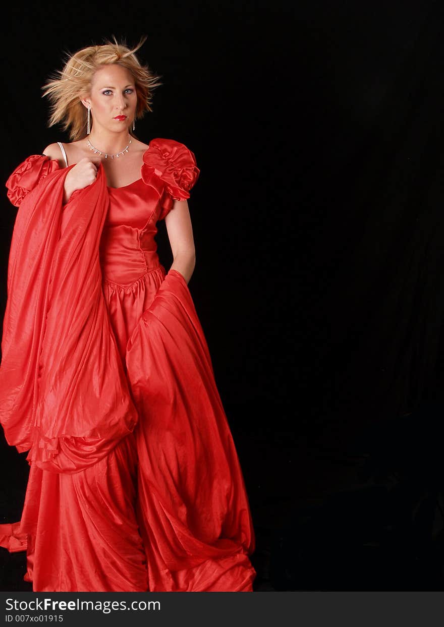 Young attractive model wrapped in red on a black background. Young attractive model wrapped in red on a black background