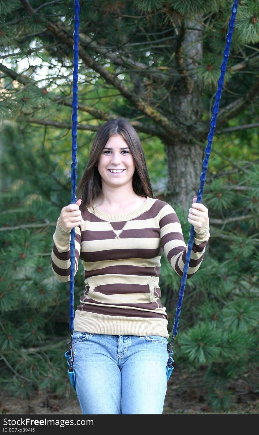 Girl outdoors smiling sitting on swing