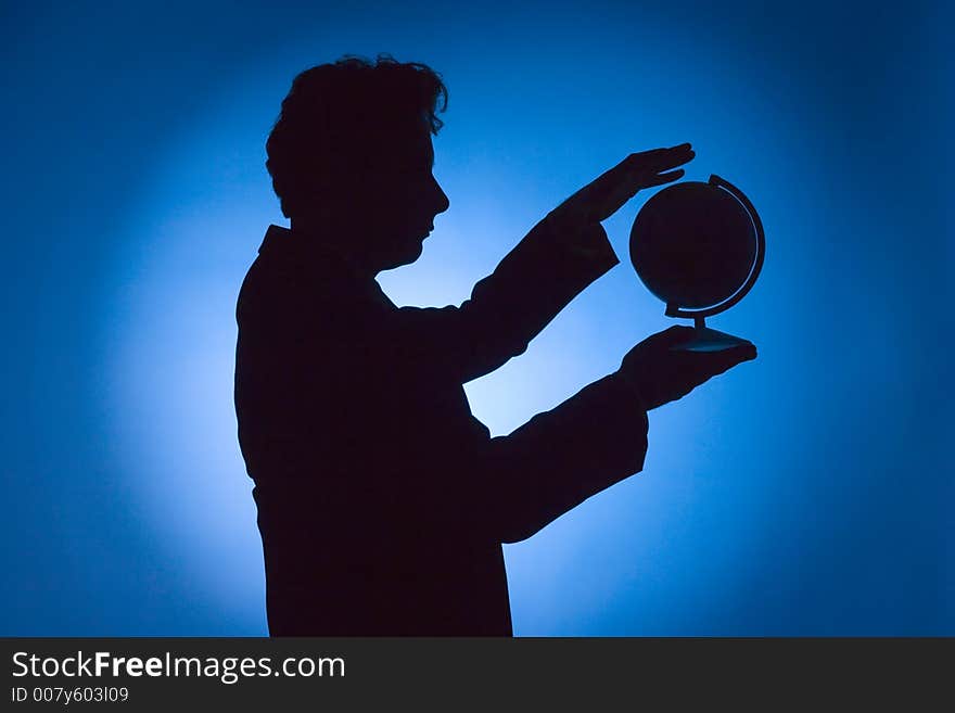 Silhouette of man with globe on blue background