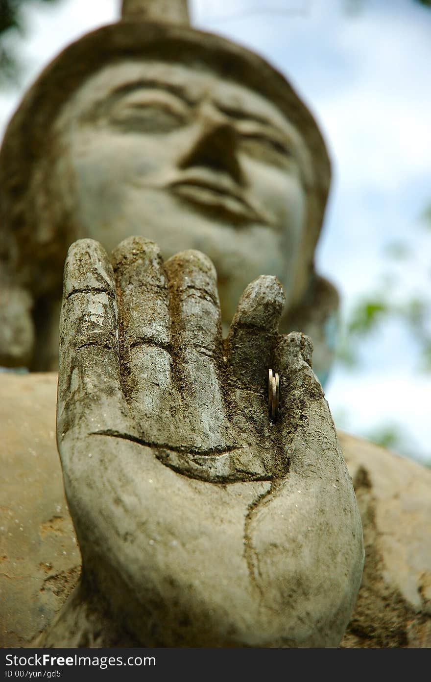 Buddha holds a few coins. Buddha holds a few coins.