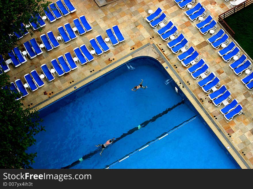 A girl and a boy swimming in the pool.