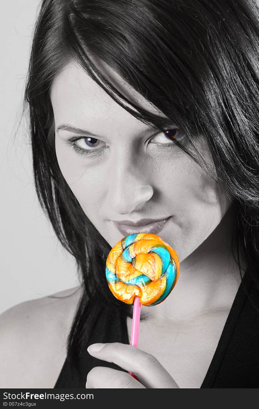 Dark hair woman with multi-coloured lollipop. Dark hair woman with multi-coloured lollipop