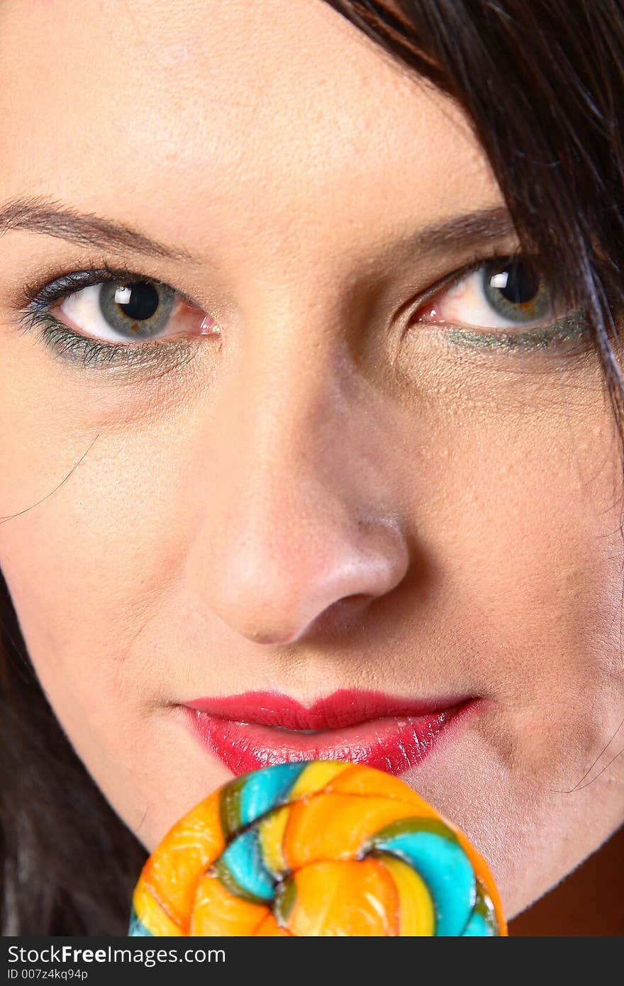 Dark hair woman with multi-coloured lollipop. Dark hair woman with multi-coloured lollipop