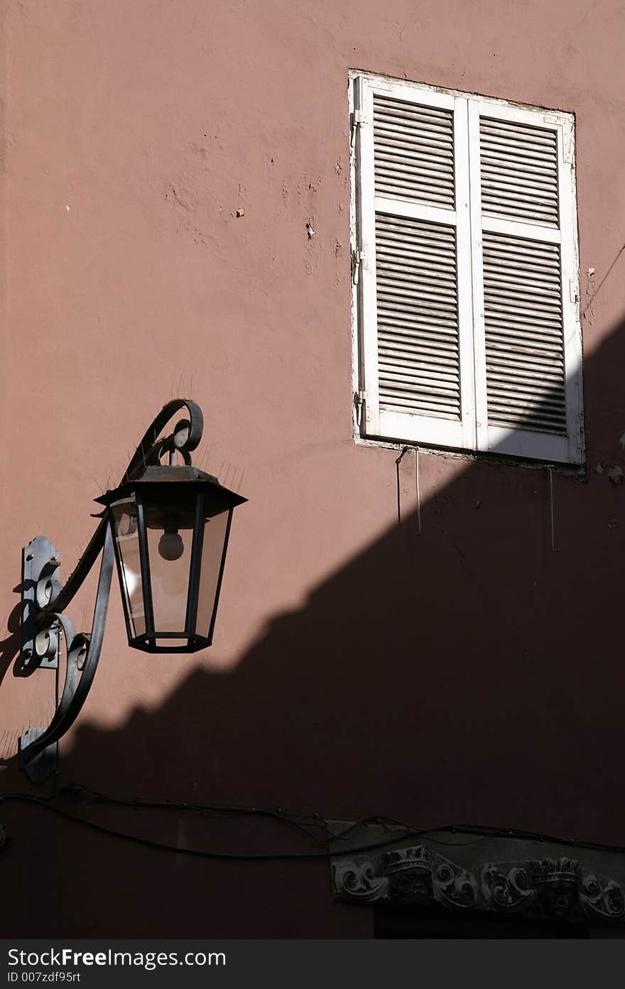 Lamp  and closed window by façade in Meran, Italy (South Tyrol), Alps. Lamp  and closed window by façade in Meran, Italy (South Tyrol), Alps