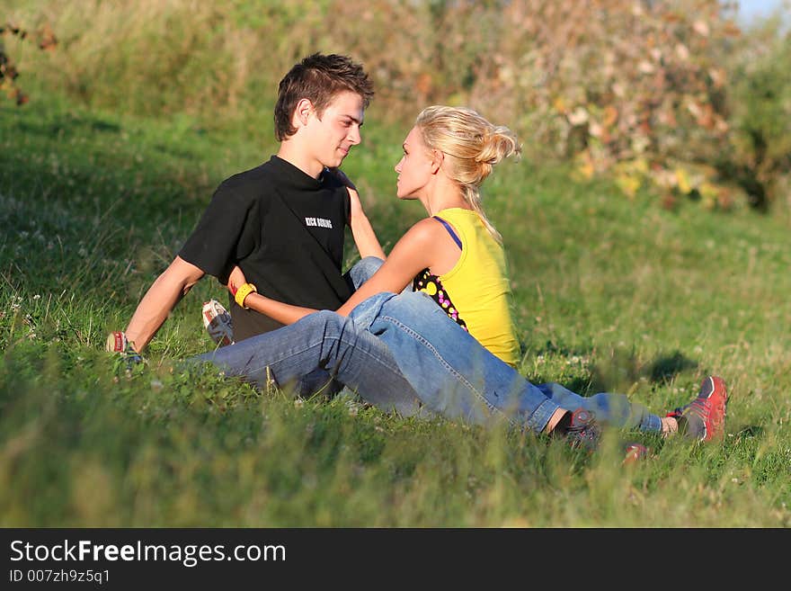 Young couple enjoying each other on the grass in the park. Young couple enjoying each other on the grass in the park