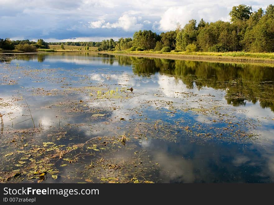 Reflection of clouds in water in the beginning of autumn. Reflection of clouds in water in the beginning of autumn