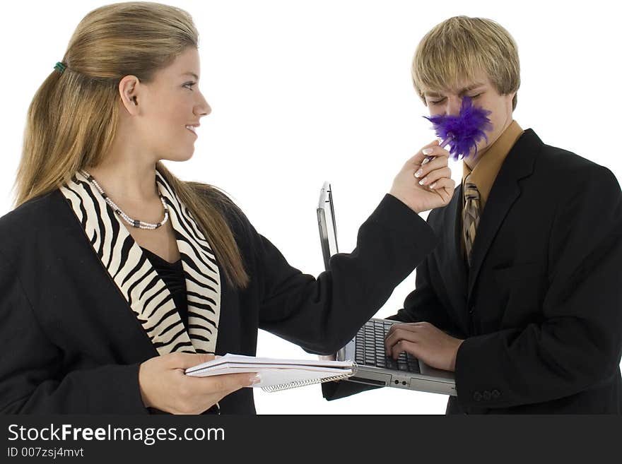 Teen girl tickles teen boy with feather pen. Dressed in business suits. Teen girl tickles teen boy with feather pen. Dressed in business suits.