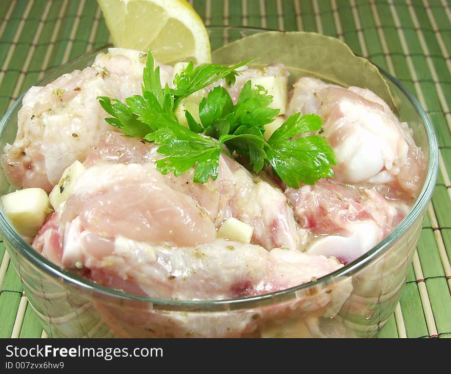 Raw uncooked wings chicken with seasonings, lemon and parsley is ready to the further culinary processing