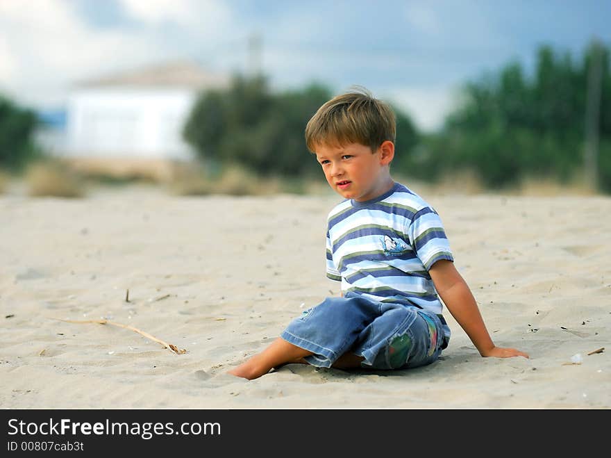 Young boy is daydreaming at the beach. Young boy is daydreaming at the beach