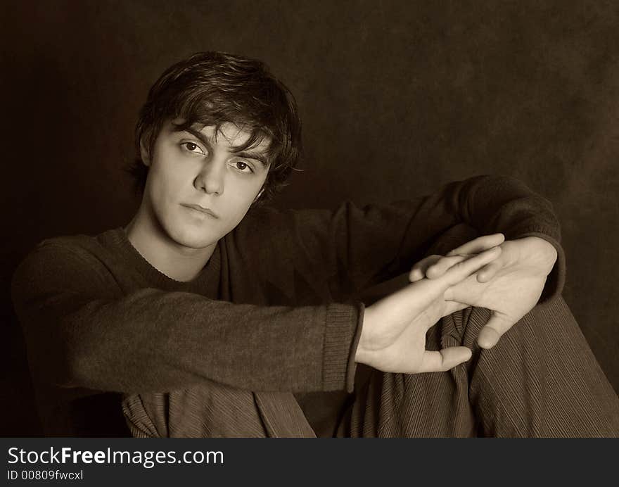 Portrait of the young in studio. Hands are crossed. b/w+sepia. Portrait of the young in studio. Hands are crossed. b/w+sepia