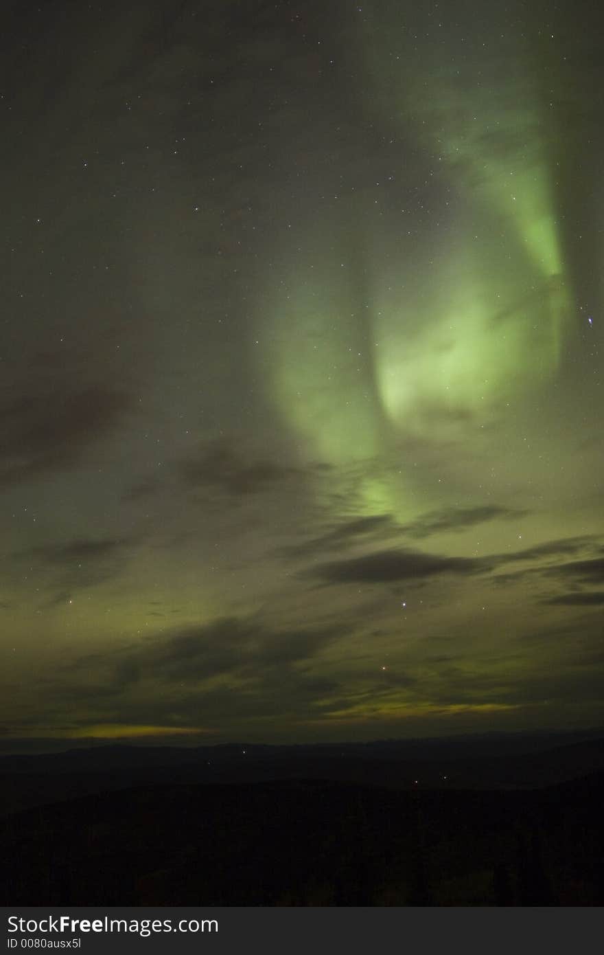 Swirling northern lights in clouds under stars. Swirling northern lights in clouds under stars