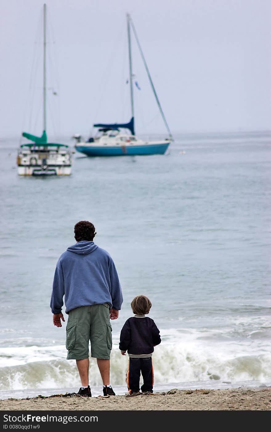 A father and his son looking at sailboats. A father and his son looking at sailboats.