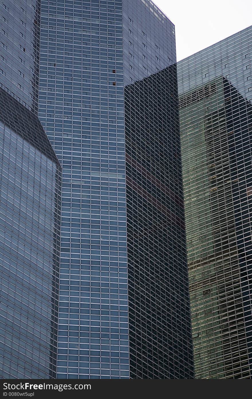 Side of three tall office buildings creating an abstract pattern.