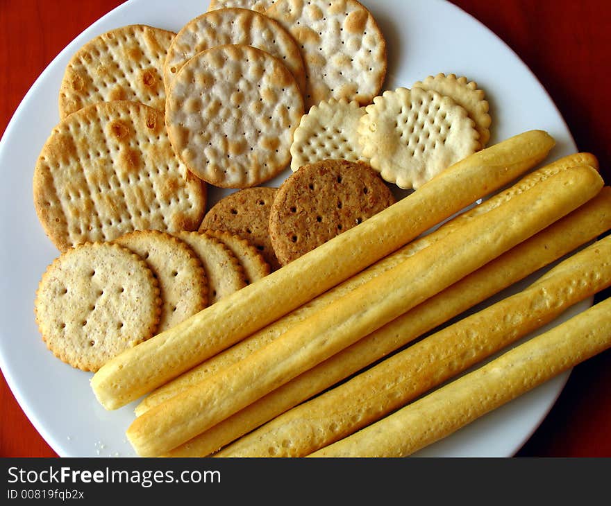 Assorted biscuits in with plate set on a wooden table.