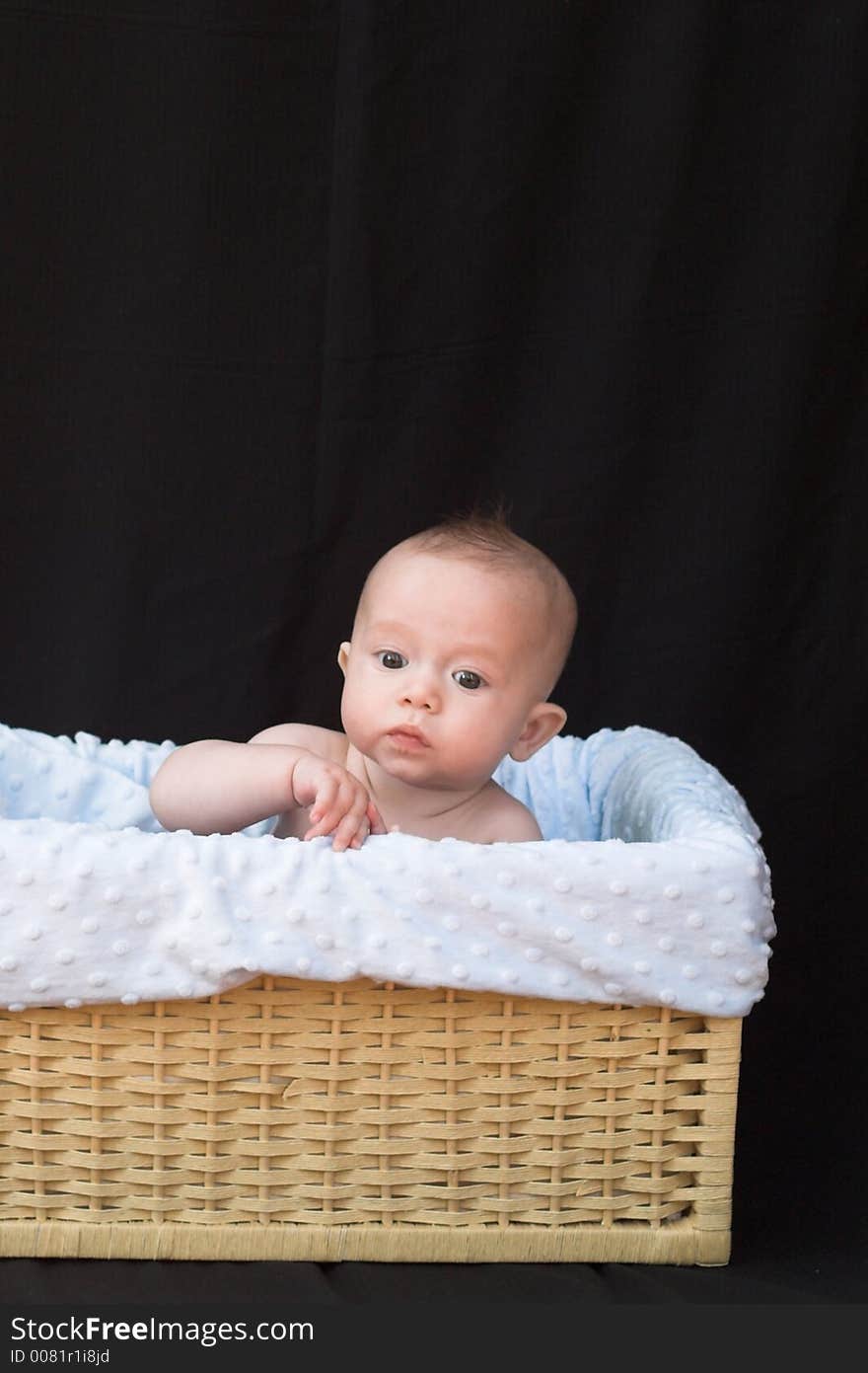 Baby boy sitting in basket. Baby boy sitting in basket