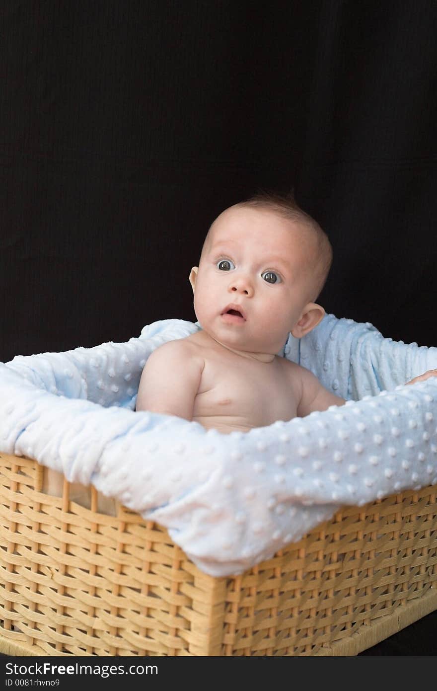 Baby boy sitting in basket. Baby boy sitting in basket