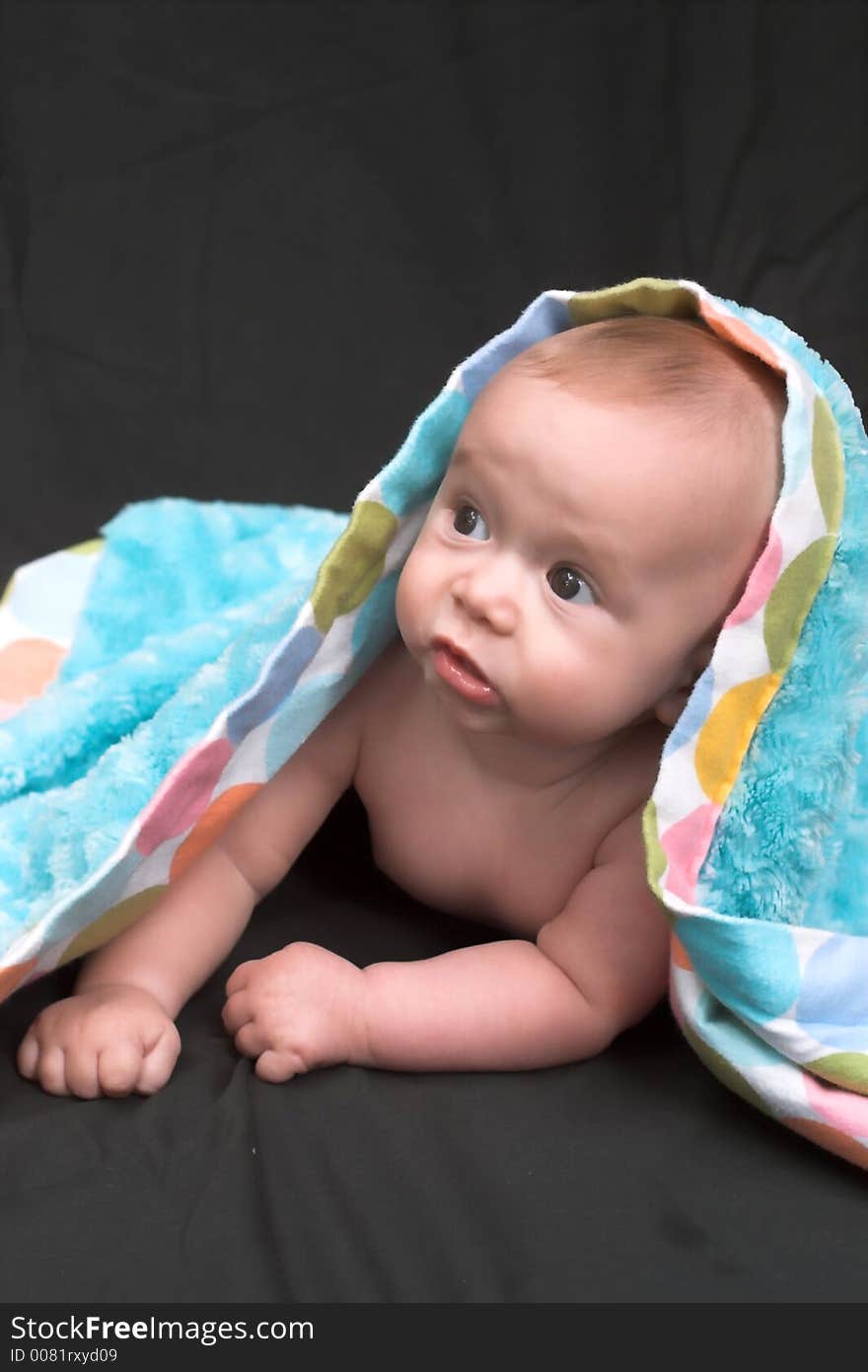 Portrait of baby boy covered by a blanket. Portrait of baby boy covered by a blanket