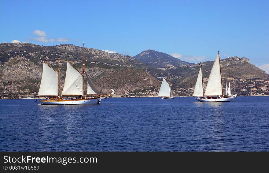 Three classic sailing yachts hoisting sails to make their get away. Three classic sailing yachts hoisting sails to make their get away.