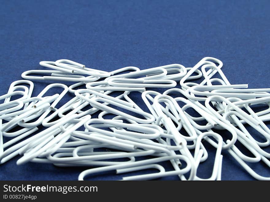 White paper clips on a blue background