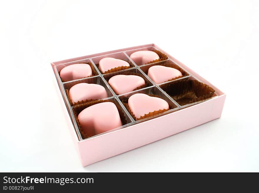 Pink love heart chocolates on a white background