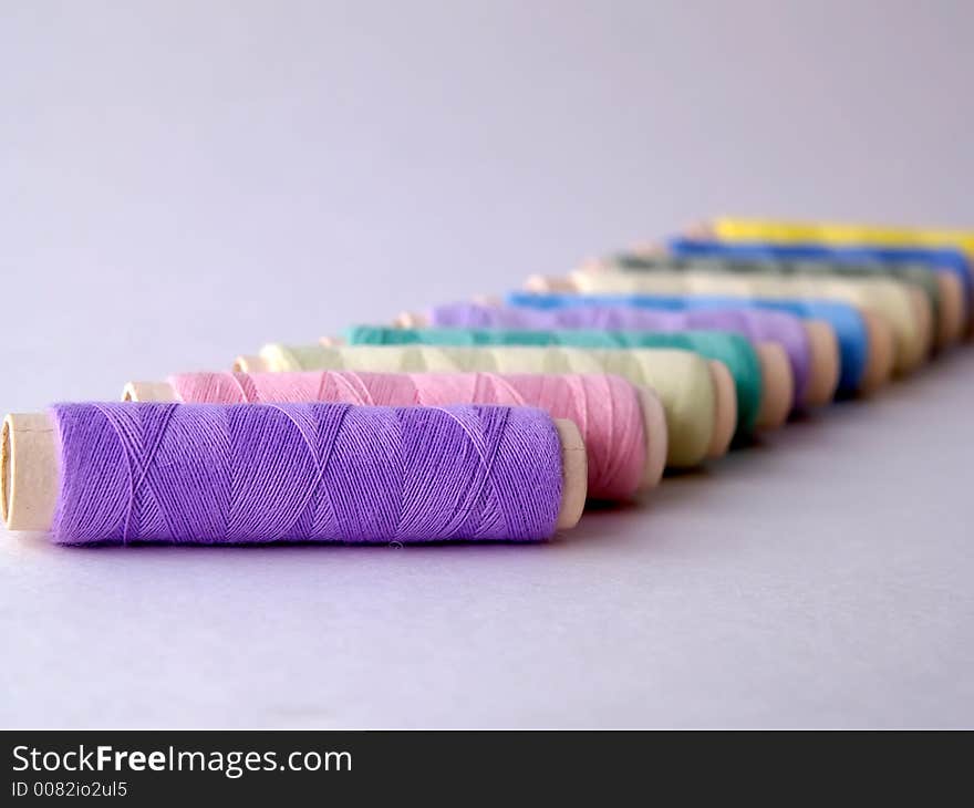 Colored sewing threads on light background