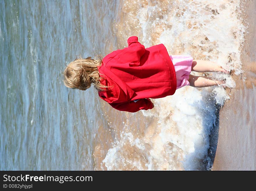 A little girl frolics in the water. A little girl frolics in the water