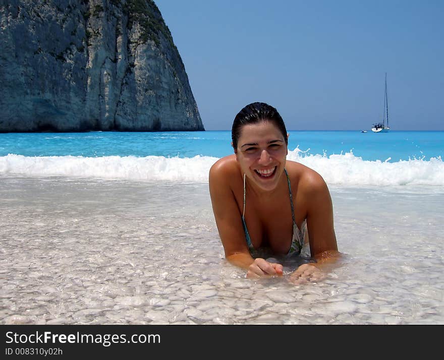 Beautiful girl enjoying the turquoise waters with yacht in the background - great holidays picture!. Beautiful girl enjoying the turquoise waters with yacht in the background - great holidays picture!