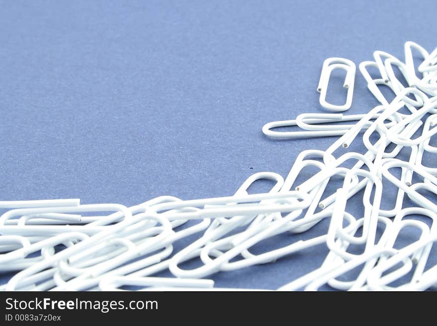 White paper clips on a blue background