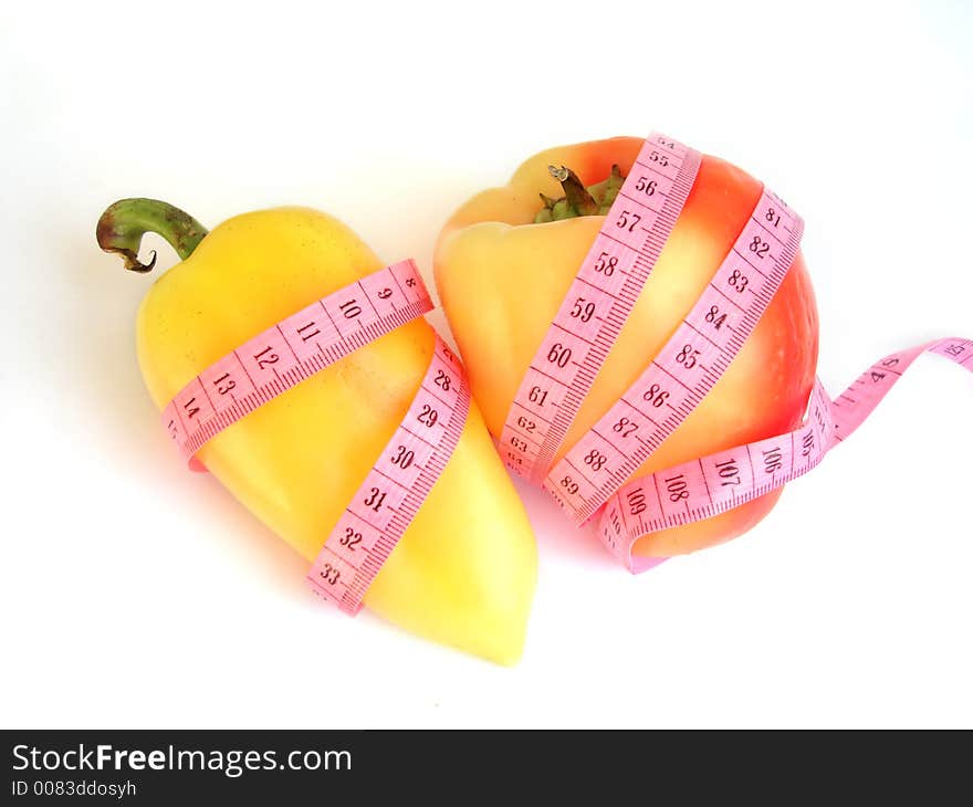 Two peppers with pink tape measure against white background