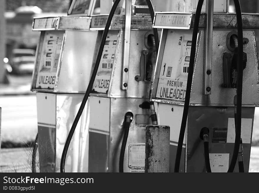 A photograph taken of an old gas station pumps. A photograph taken of an old gas station pumps.