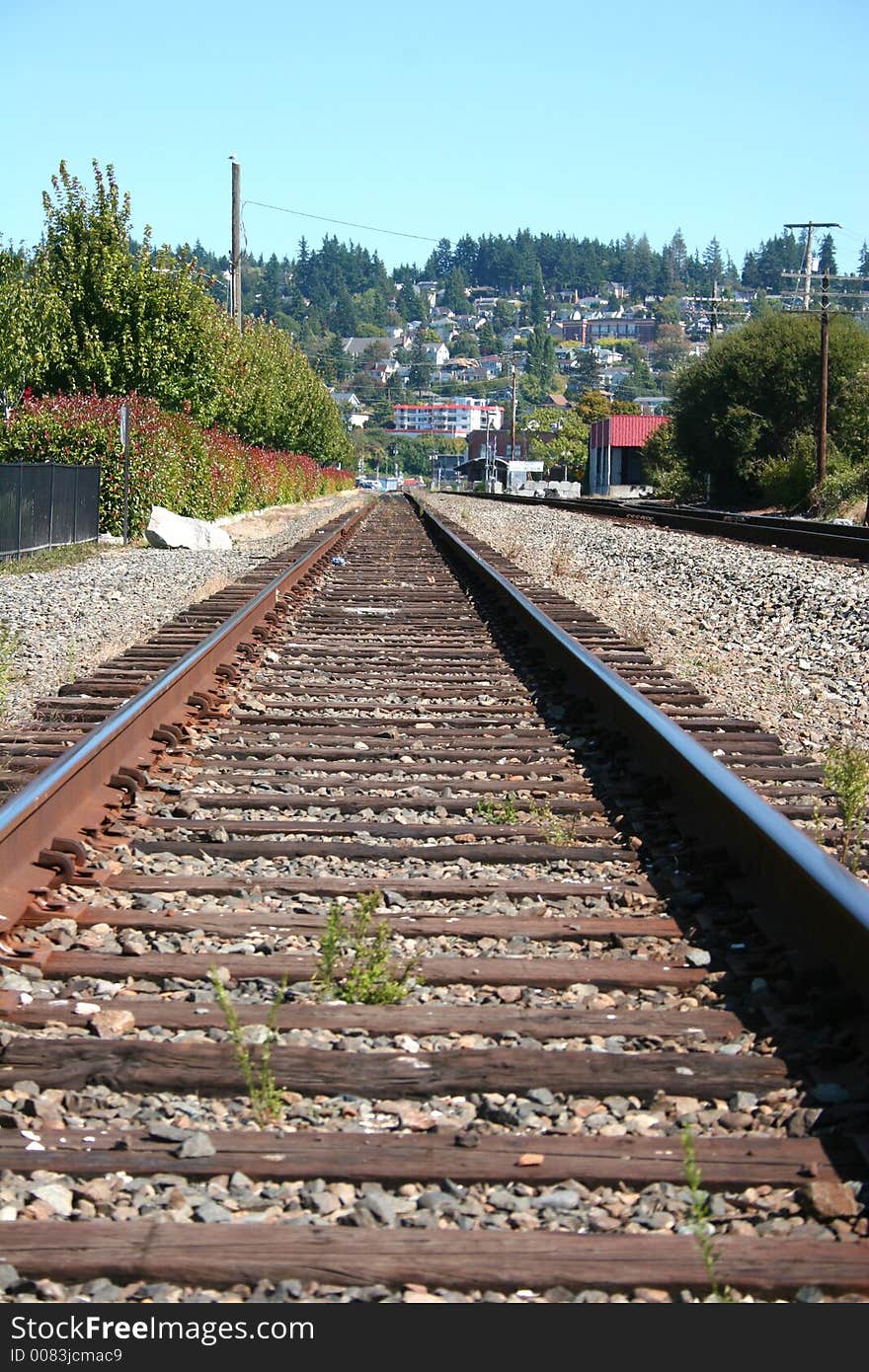 Railroad tracks leading into distant town. Railroad tracks leading into distant town