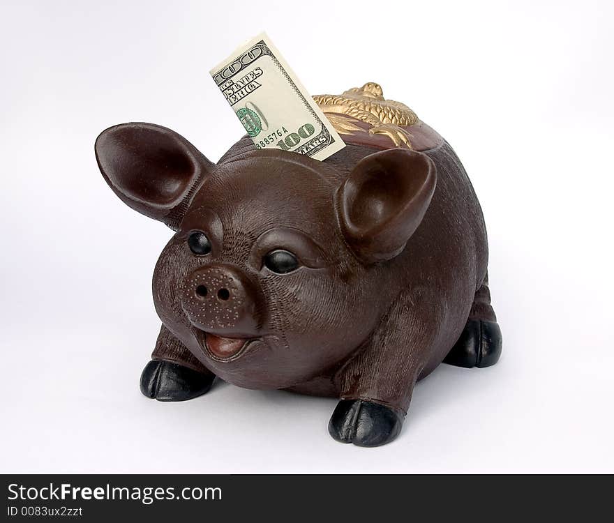 Piggy bank with U.S. one hundred dollars in slot