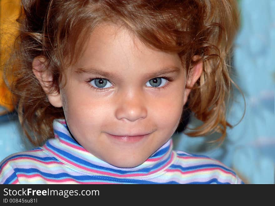 A young girl with big blue eyes and pigtails with a sweet smile