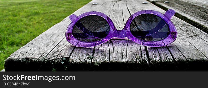 Pink sunglasses on a park bench