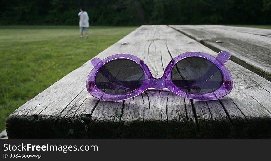 Pink sunglasses on a park bench