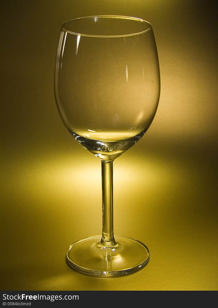 Empty wineglass in gold fon