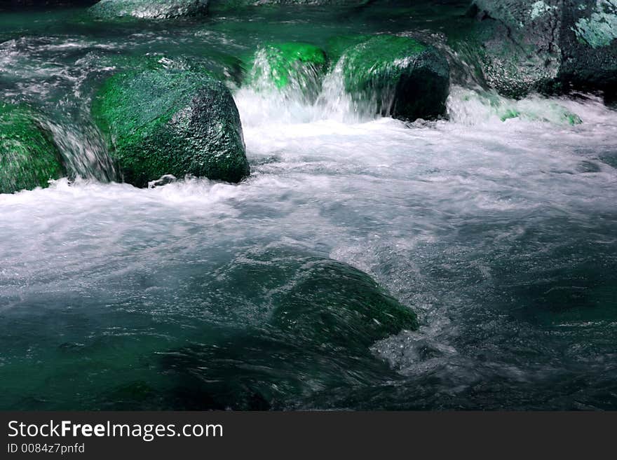 A small stream with rocks and white water. A small stream with rocks and white water.