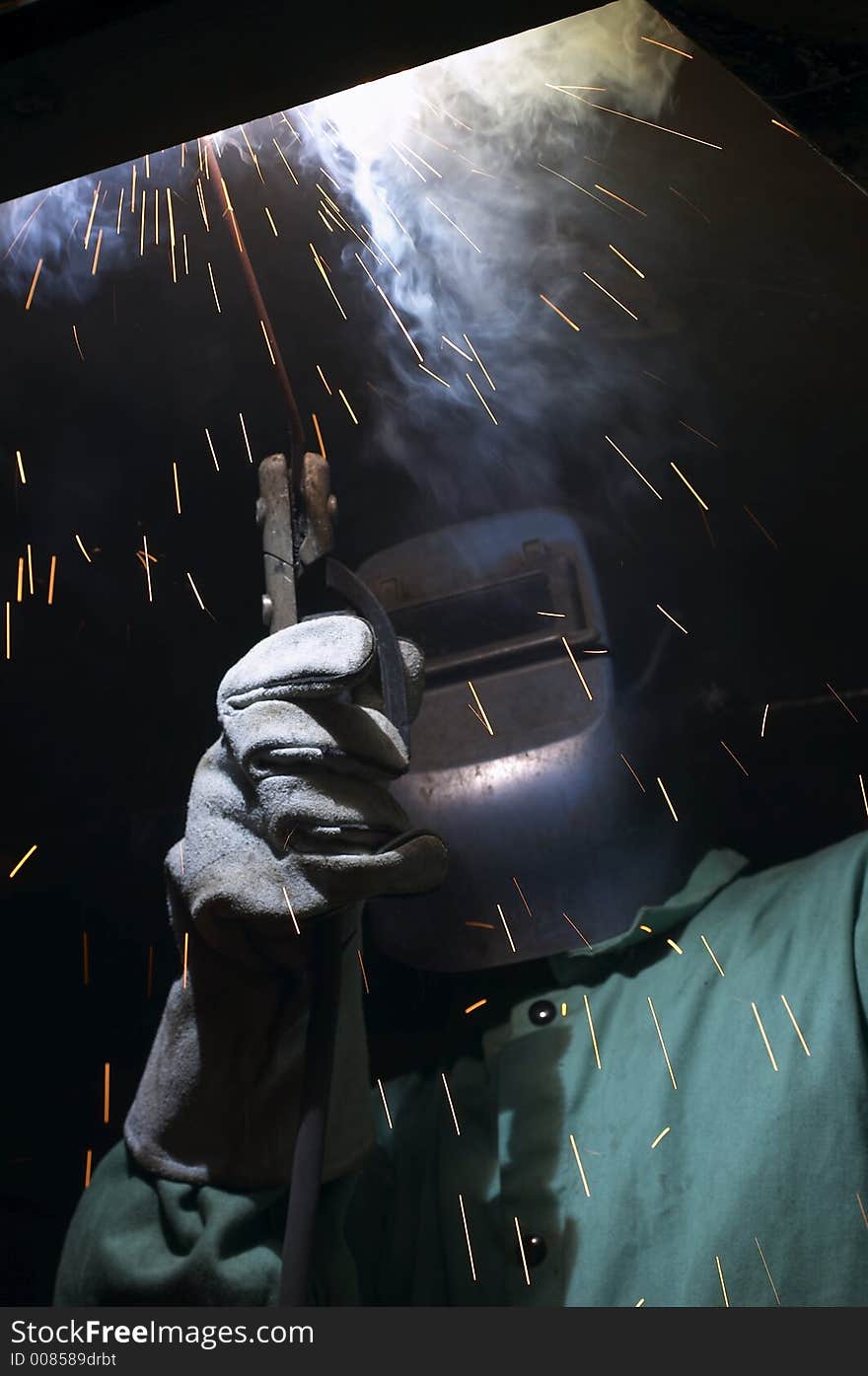 Welder working overhead at night. Welder working overhead at night