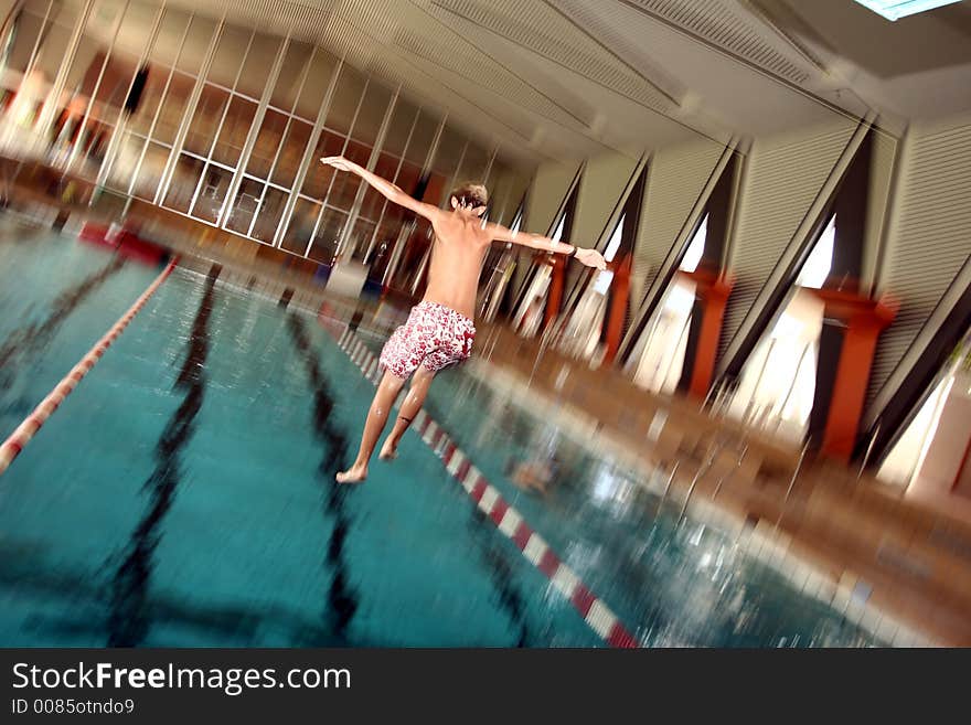 Indoor swimming pool fun, girl diving, motion blur