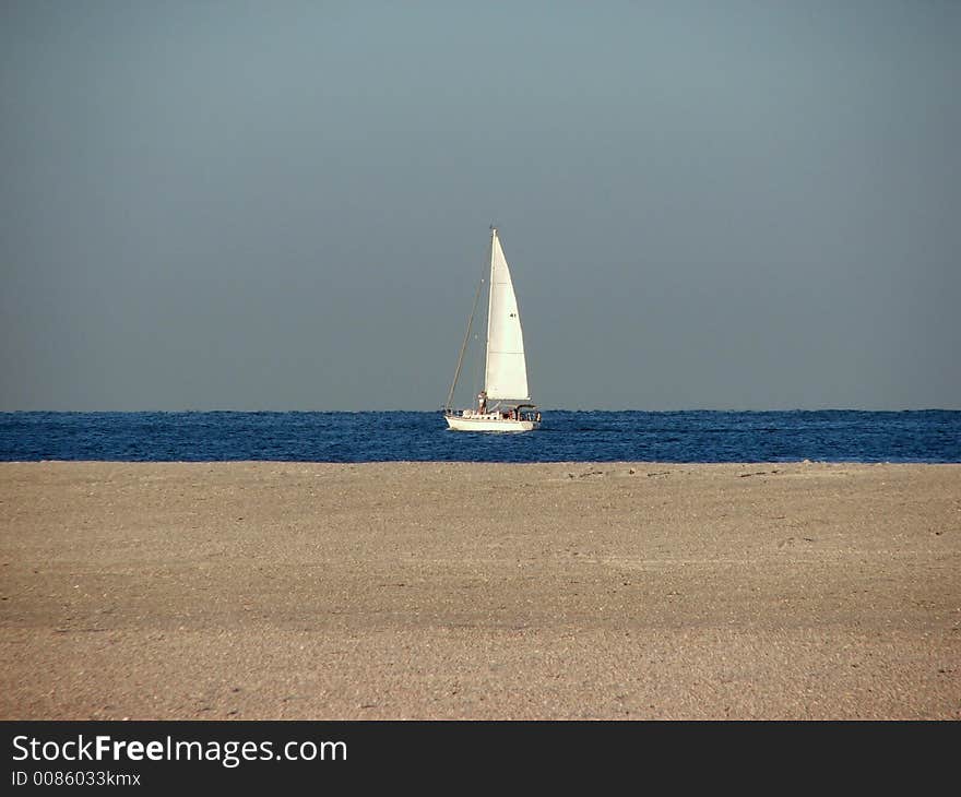 This sailboat heads out for a day of sailing on the gulf. This sailboat heads out for a day of sailing on the gulf.