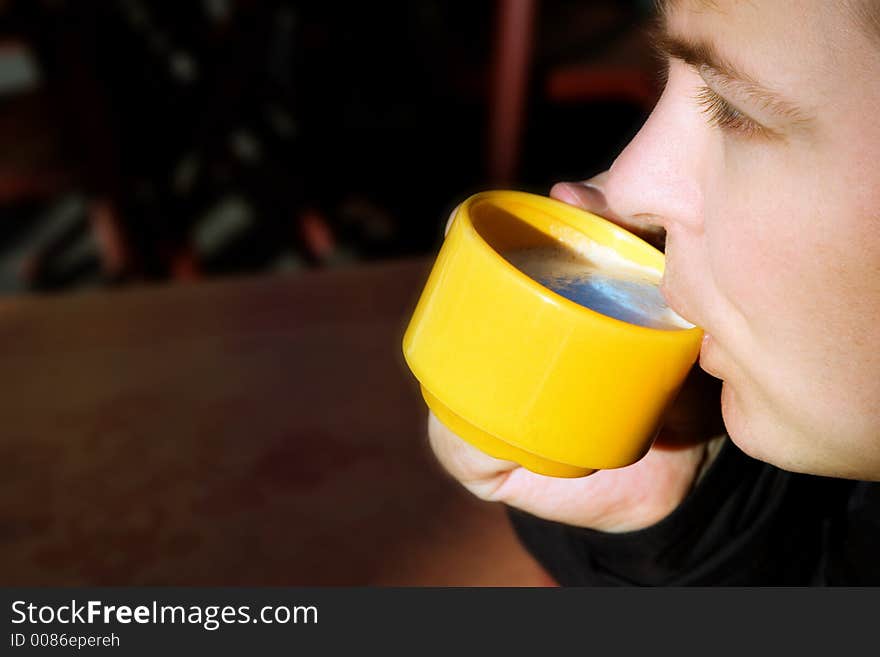 Young man drinking coffee outside