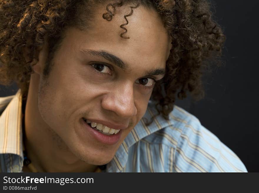 Nice guy smiling against a dark grey background. Nice guy smiling against a dark grey background