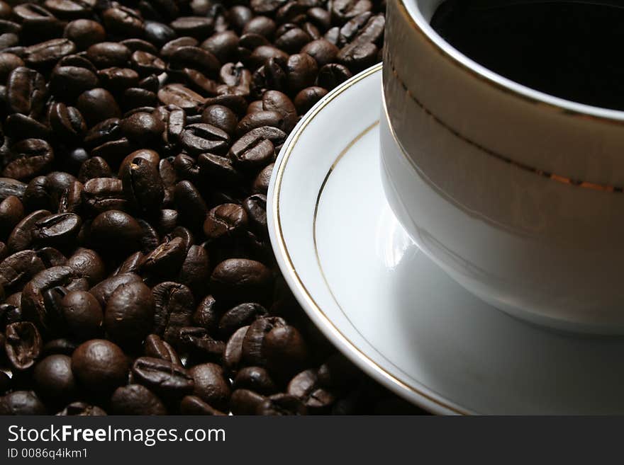 Cup of coffee on a background of fried coffee grains. Cup of coffee on a background of fried coffee grains