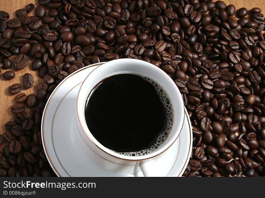 Cup of coffee on a background of fried coffee grains. Cup of coffee on a background of fried coffee grains