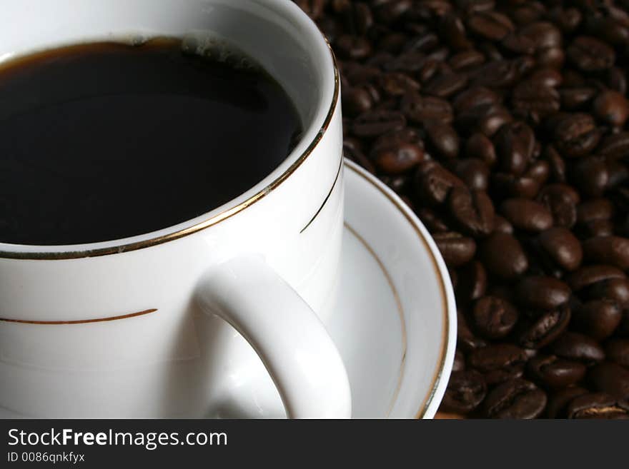 Cup of coffee on a background of fried coffee grains. Cup of coffee on a background of fried coffee grains