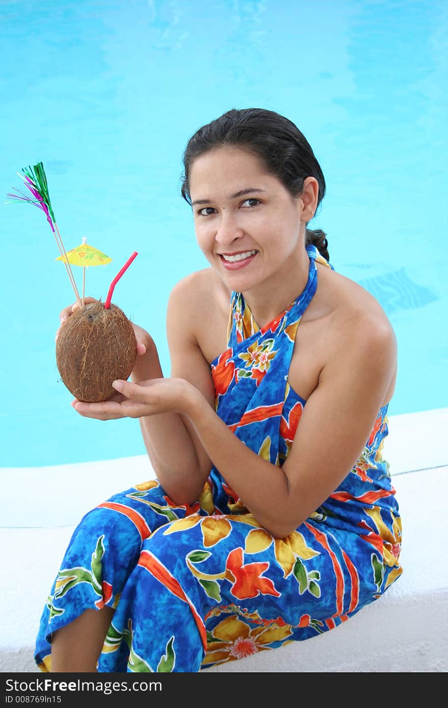 Young woman drinking coconut milk by the water. Young woman drinking coconut milk by the water