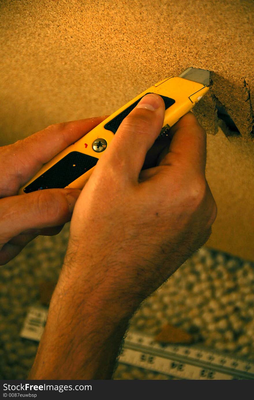 A worker is cutting a wood board