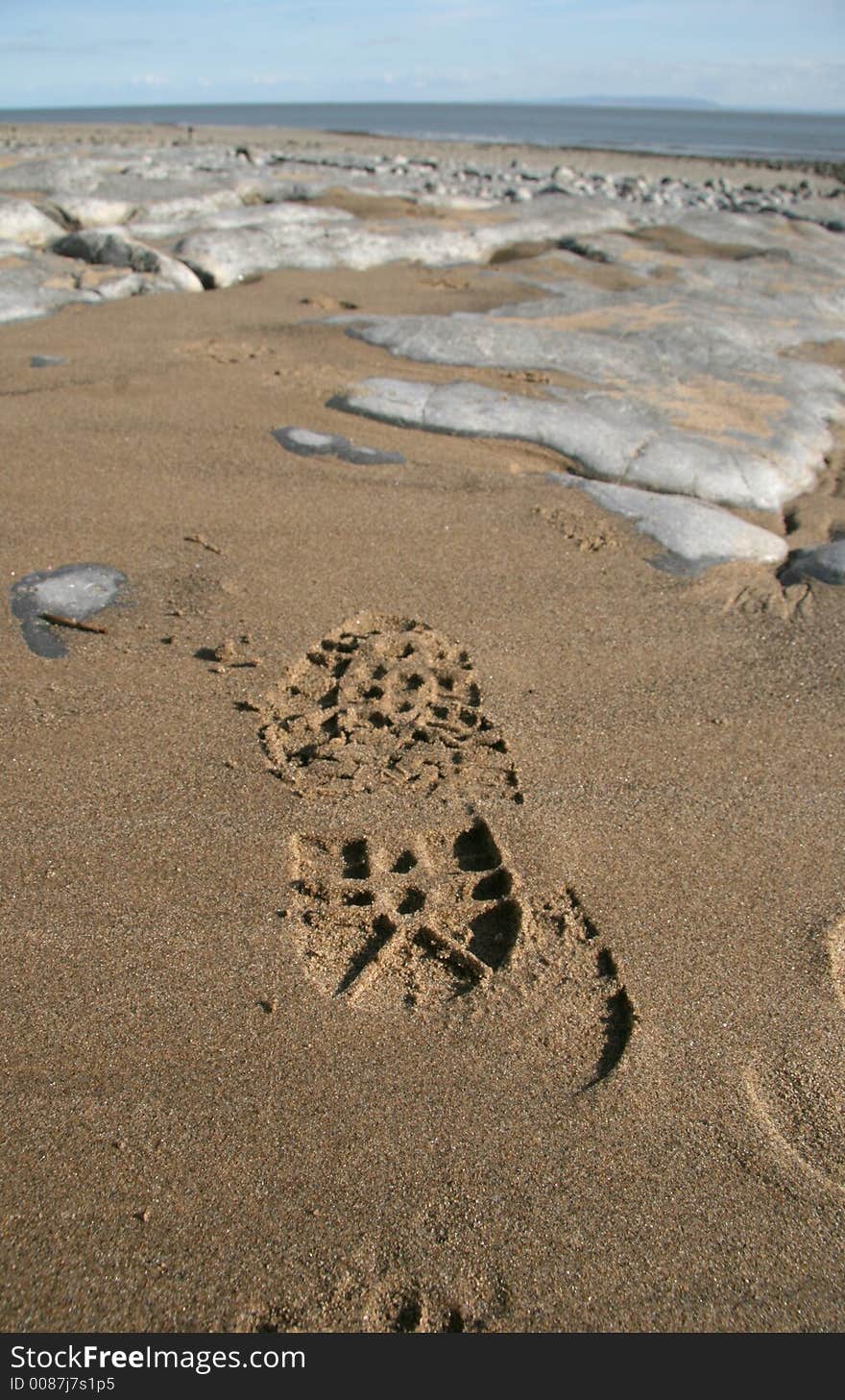 Footprint on wet sand on rock